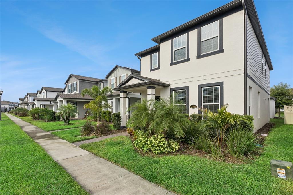 A two-story suburban house with a light-colored stucco exterior and a front porch — 13879 LANYARD WAY, WINTER GARDEN, FL
