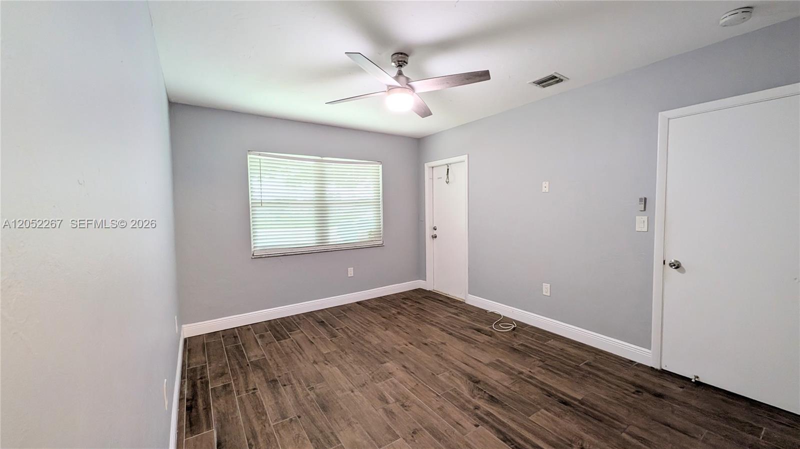 An empty bedroom features light gray walls, wood-look tile flooring, and a ceiling fan — 315 SE 23rd Ave # 5, Pompano Beach FL 33062, POMPANO BEACH, FL