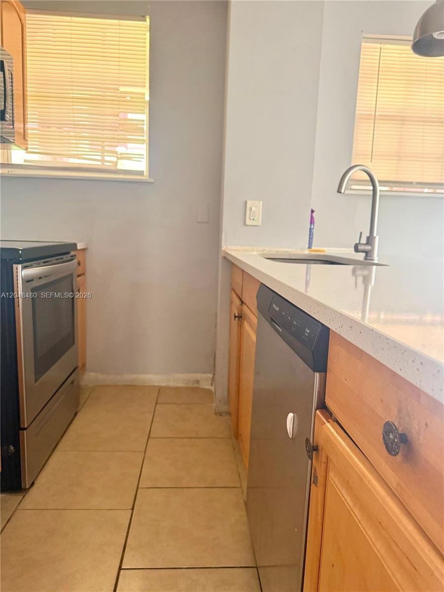 A kitchen features stainless steel appliances, light wood cabinets, and a white countertop — 14240 NW 22nd Ave # 1, Opa-Locka FL 33054, OPA-LOCKA, FL