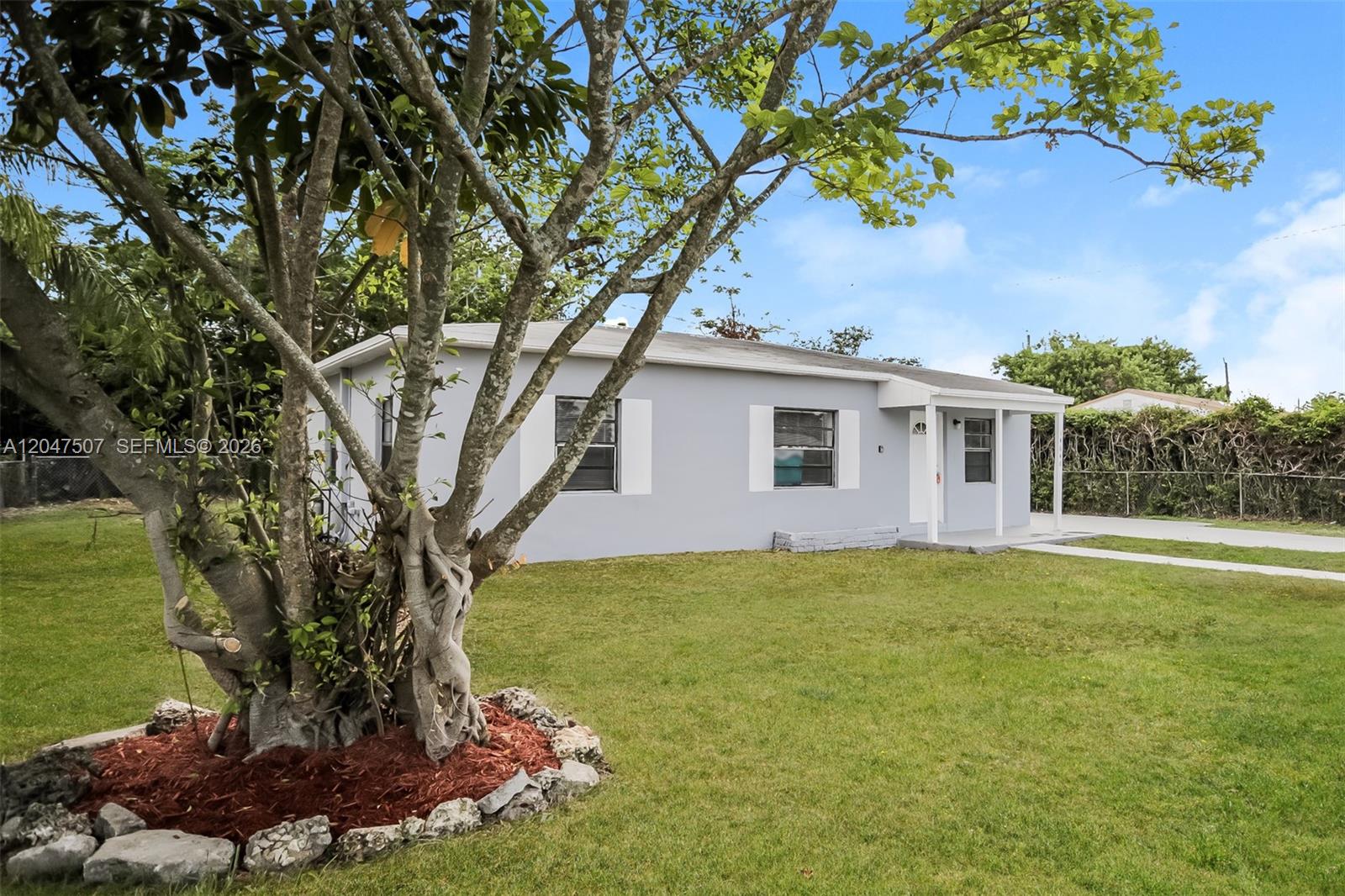 A light gray single-story house with white shutters sits behind a large tree — 14640 Tyler St, Miami FL 33176, MIAMI, FL