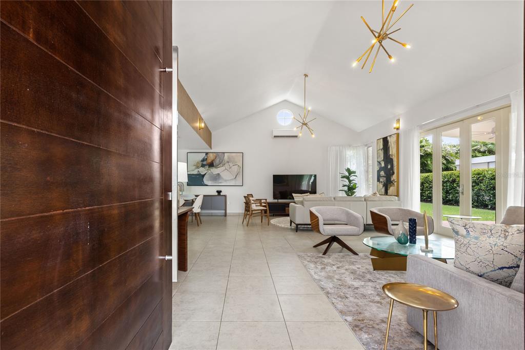 A view from an entryway into a bright living room with vaulted ceilings and tile floors — 418 CAMINO DEL SUSUA, DORADO, PR