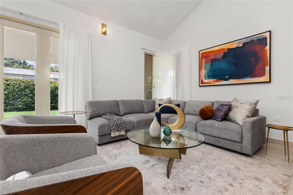A living room features a grey sectional sofa, a glass coffee table, and abstract wall art — 418 CAMINO DEL SUSUA, DORADO, PR