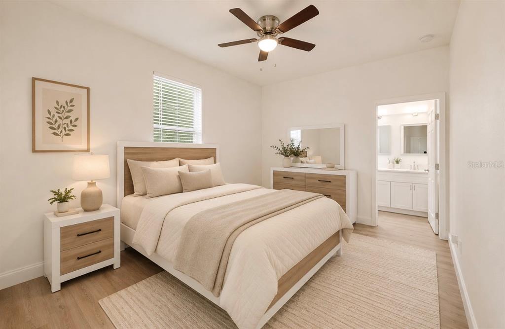 A bedroom features a bed with neutral bedding, a nightstand, a dresser, and an attached bathroom — 3706 WIGGINS LEAF STREET, TAMPA, FL