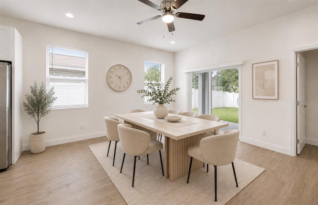 A dining room features a light wood table, six beige chairs, and a ceiling fan — 3706 WIGGINS LEAF STREET, TAMPA, FL
