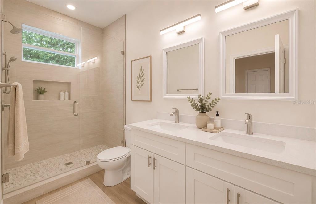 A modern bathroom features a glass-enclosed walk-in shower, a double vanity, and light-colored tile — 3706 WIGGINS LEAF STREET, TAMPA, FL