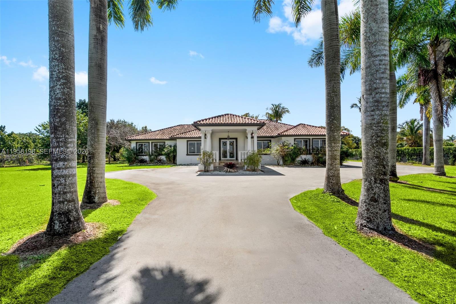 A single-story house with a tiled roof and a paved driveway framed by palm trees — 16800 SW 190th St, Miami FL 33187, MIAMI, FL