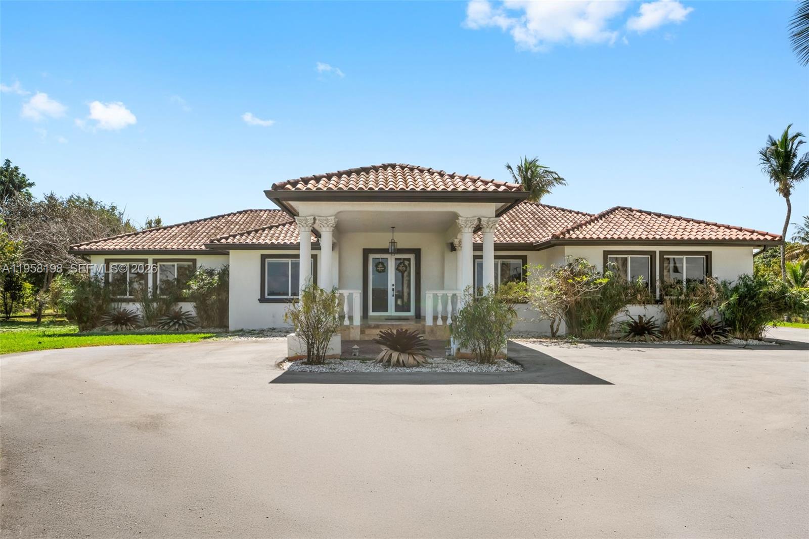 A single-story house with a tiled roof and a covered entryway featuring white columns — 16800 SW 190th St, Miami FL 33187, MIAMI, FL