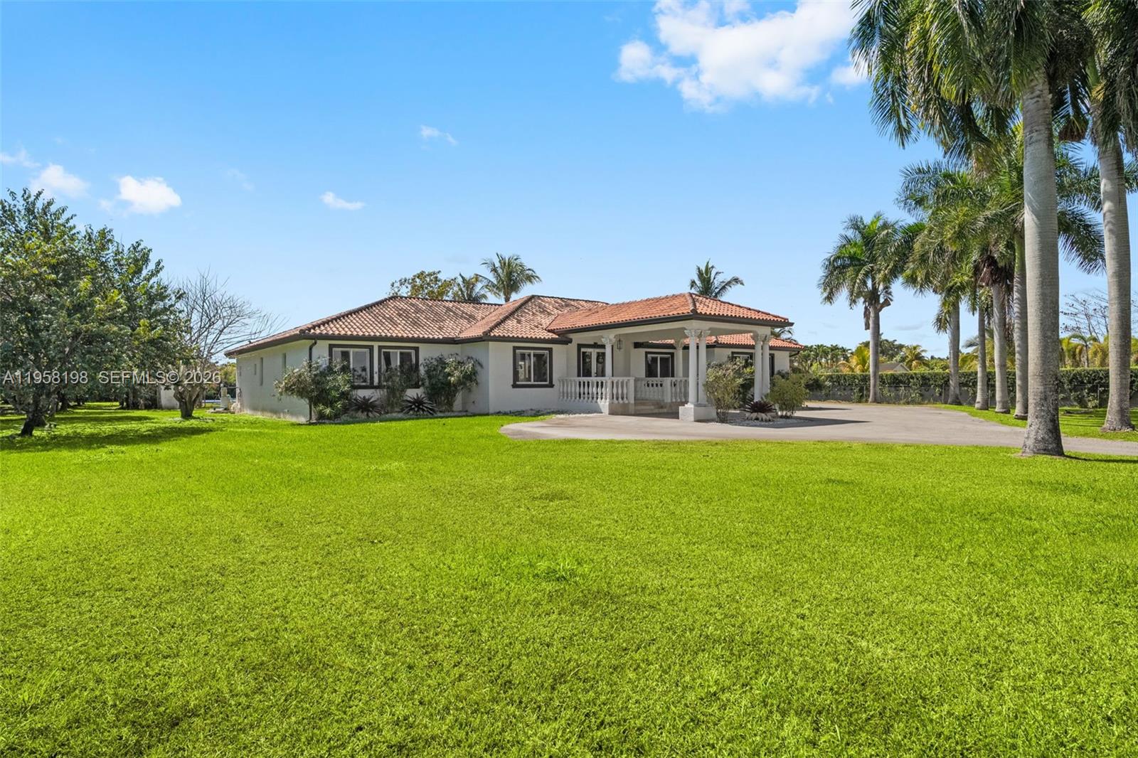 A single-story house with a tiled roof and a covered entrance sits on a lawn — 16800 SW 190th St, Miami FL 33187, MIAMI, FL