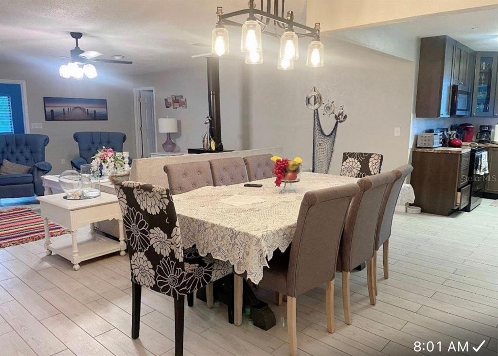 A dining area with a lace-covered table and upholstered chairs sits adjacent to a kitchen — 400 PALM AVENUE, ORMOND BEACH, FL