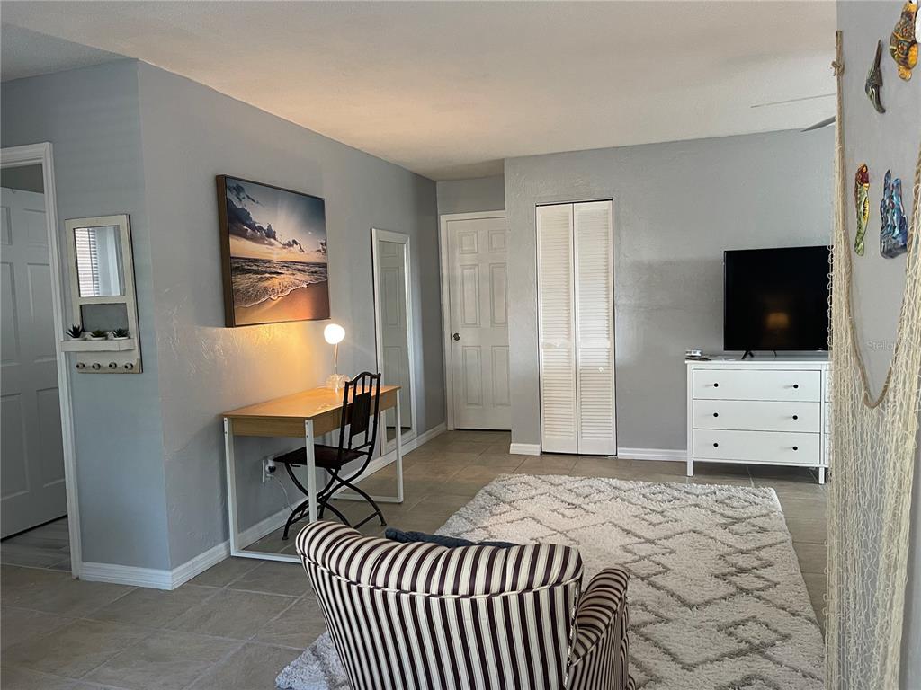 A living room features a striped armchair, a desk, a white dresser, and a television — 400 PALM AVENUE, ORMOND BEACH, FL