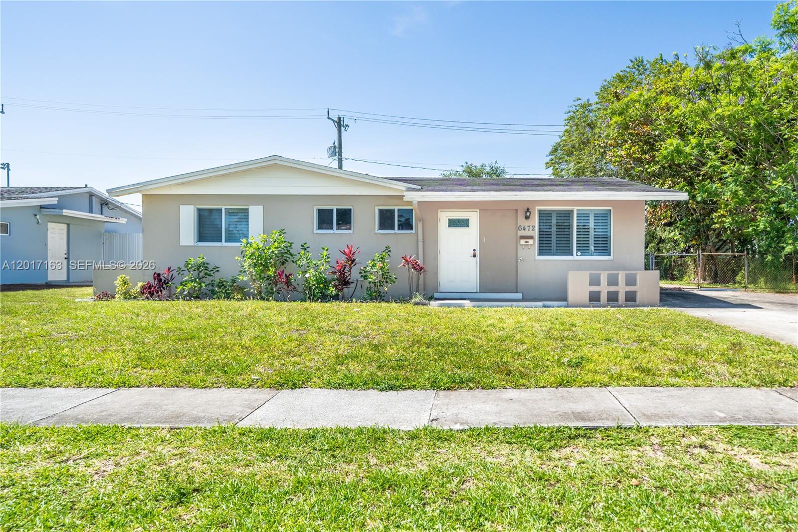 A single-story house with a beige exterior, white trim, and a front lawn — 6472 Pierce St, Hollywood FL 33024, HOLLYWOOD, FL