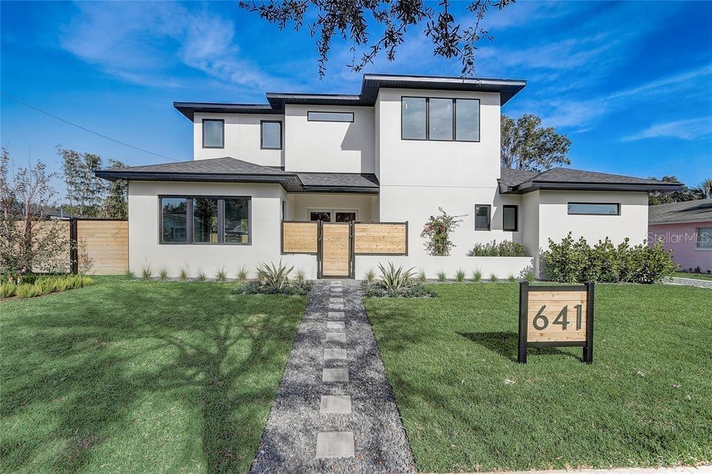 A modern two-story house with white stucco, a dark roof, and a stone walkway — 641 NORTHWOOD CIRCLE, WINTER PARK, FL