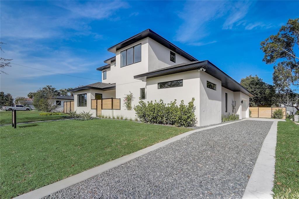 A modern two-story house with white stucco siding, a gravel driveway, and a green lawn — 641 NORTHWOOD CIRCLE, WINTER PARK, FL