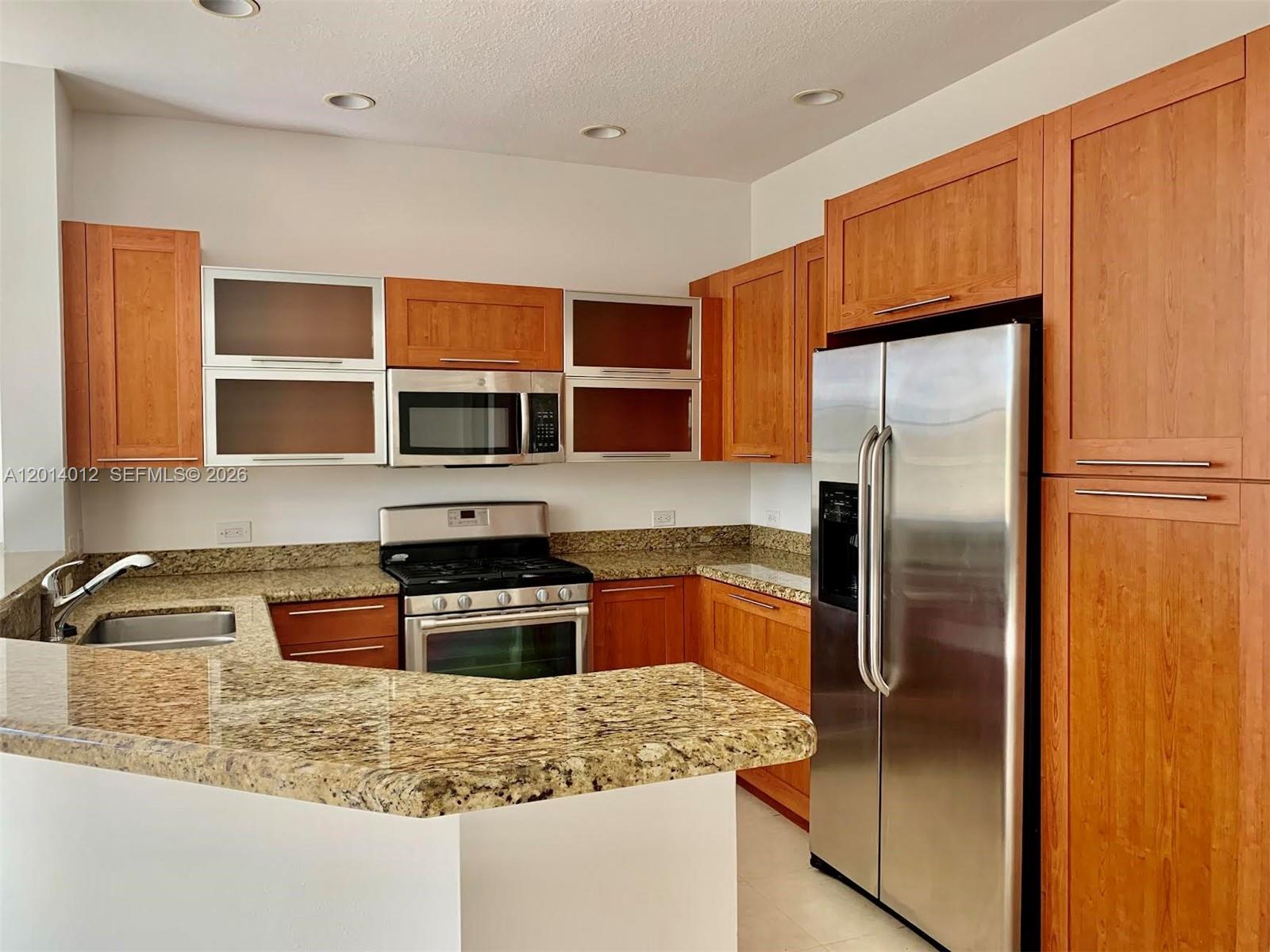 A kitchen features wood cabinets, granite countertops, and stainless steel appliances — 2955 NW 126th Ave # 5, Sunrise FL 33323, SUNRISE, FL