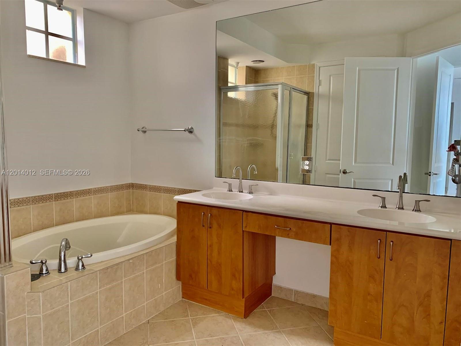 A bathroom features a soaking tub, a double vanity with wood cabinets, and a mirror — 2955 NW 126th Ave # 5, Sunrise FL 33323, SUNRISE, FL