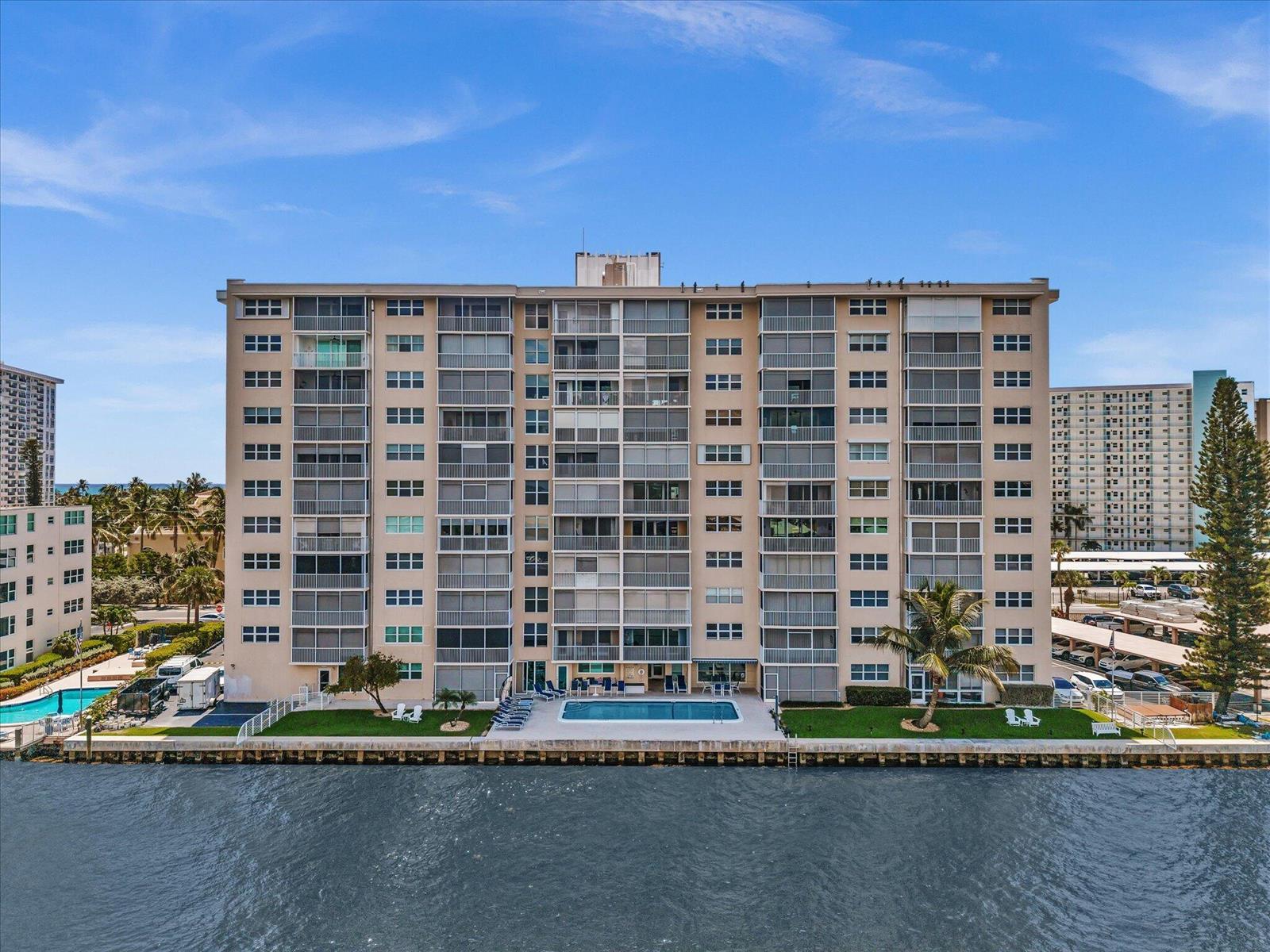 An exterior view of a multi-story waterfront apartment building with a swimming pool — 303 N Riverside Drive # 503, Pompano Beach FL 33062, POMPANO BEACH, FL