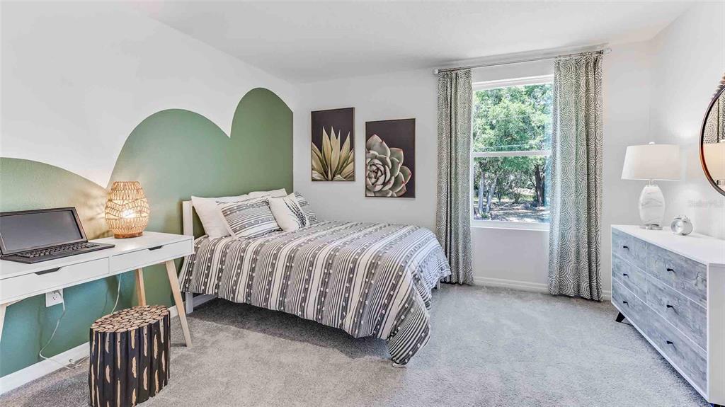 A bedroom features a green arched wall accent, a striped bed, and a white desk — 17924 ACORN DROP ROAD, LAND O LAKES, FL
