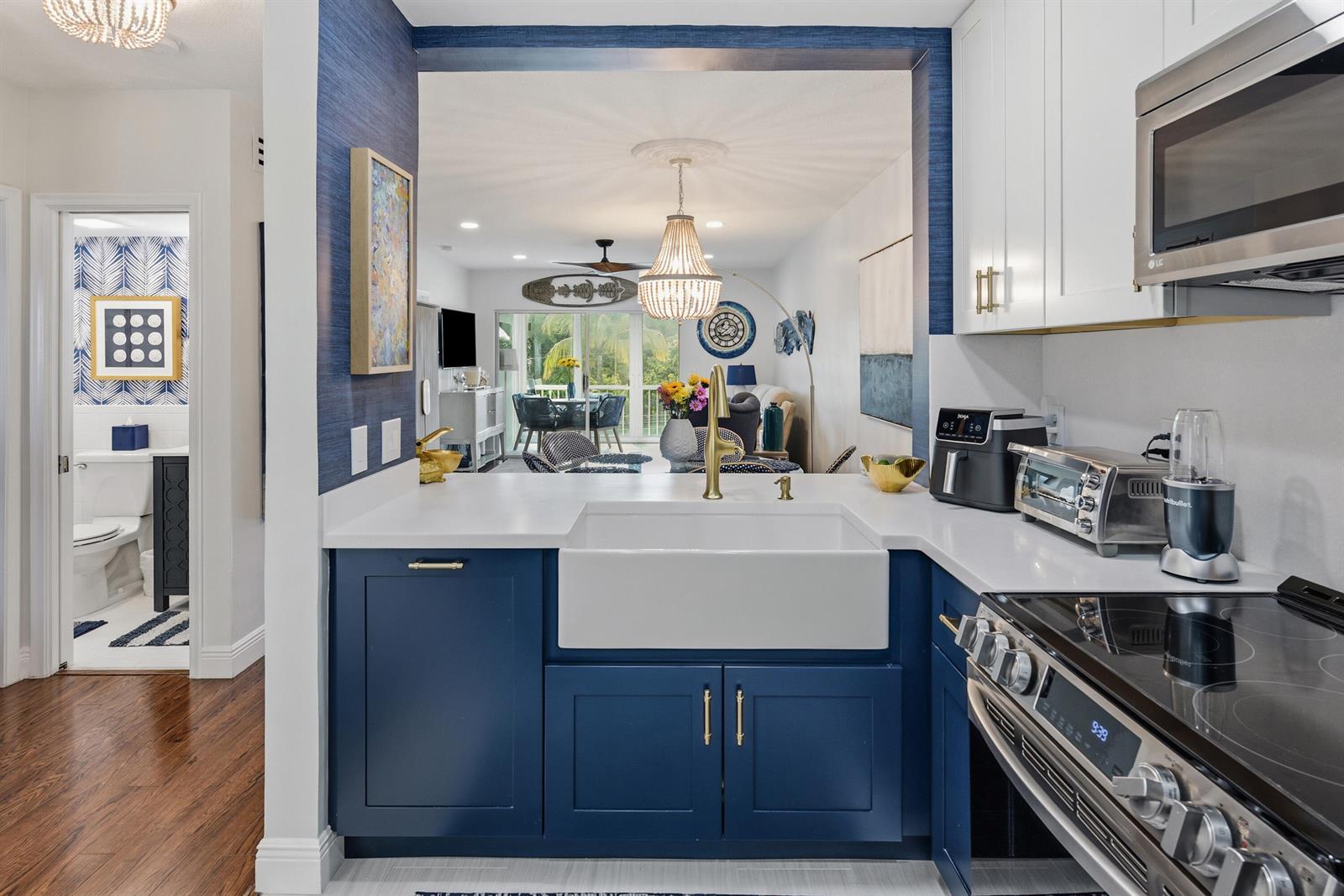 A kitchen with blue cabinets, a white farmhouse sink, and a view into the living area — 6530 N Ocean Boulevard # 3070, Ocean Ridge FL 33435, OCEAN RIDGE, FL