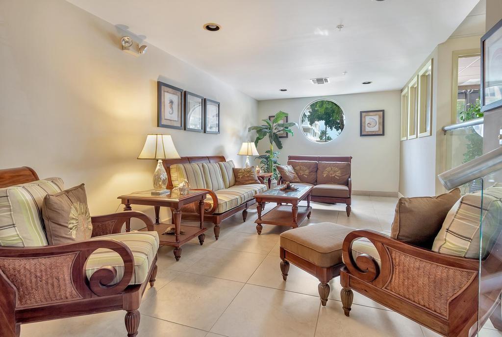 A furnished lobby area features wooden seating, a coffee table, and a circular window — 1009 N Ocean Boulevard N # 503, Pompano Beach FL 33062, POMPANO BEACH, FL