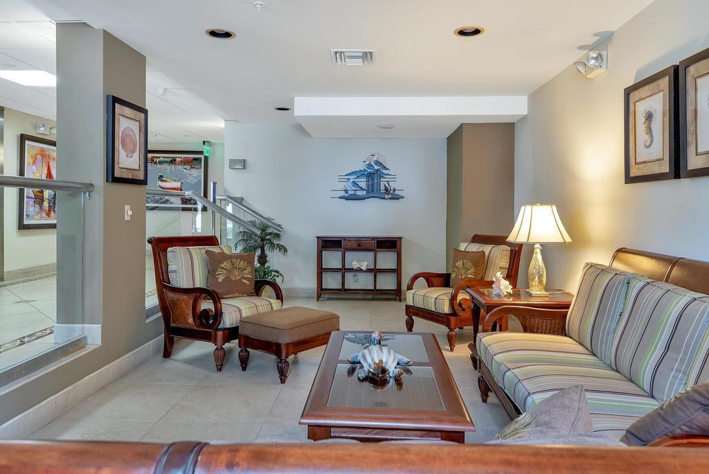 A furnished lobby area features a seating group with striped sofas, armchairs, and a coffee table — 1009 N Ocean Boulevard N # 503, Pompano Beach FL 33062, POMPANO BEACH, FL