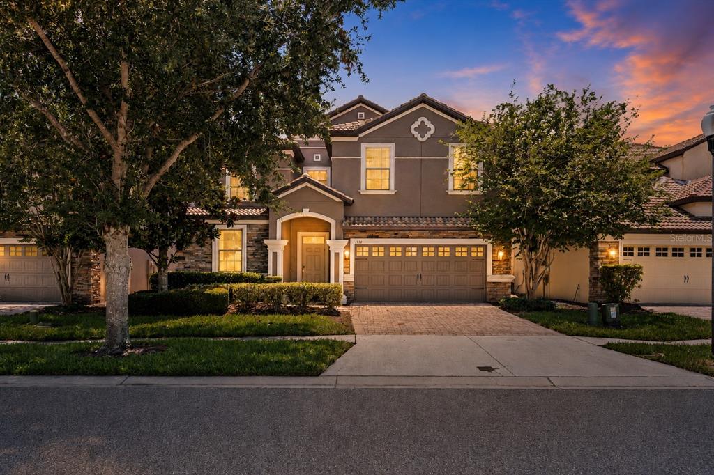 A two-story suburban house with a stone and stucco facade and a three-car garage — 1530 MOON VALLEY DRIVE, DAVENPORT, FL