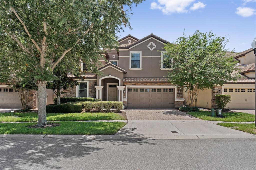 A two-story suburban house with a stone and stucco facade and a two-car garage — 1530 MOON VALLEY DRIVE, DAVENPORT, FL