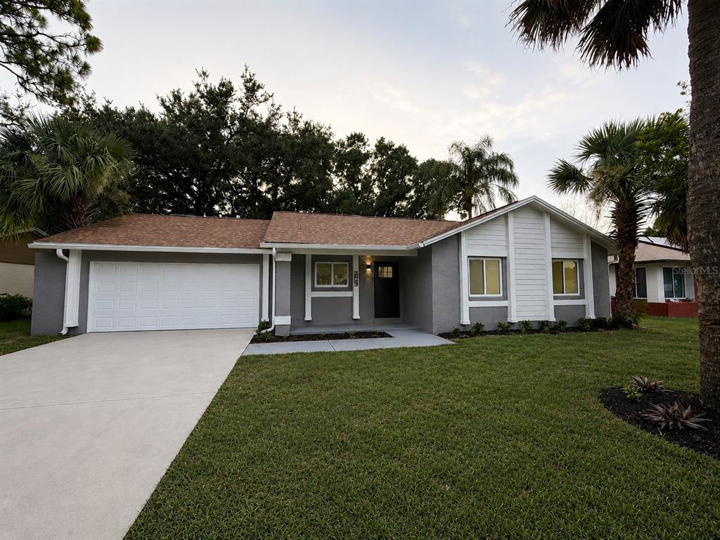 A single-story house with a gray exterior, white trim, and a two-car garage — 10722 WHISPERWOOD LANE, ORLANDO, FL