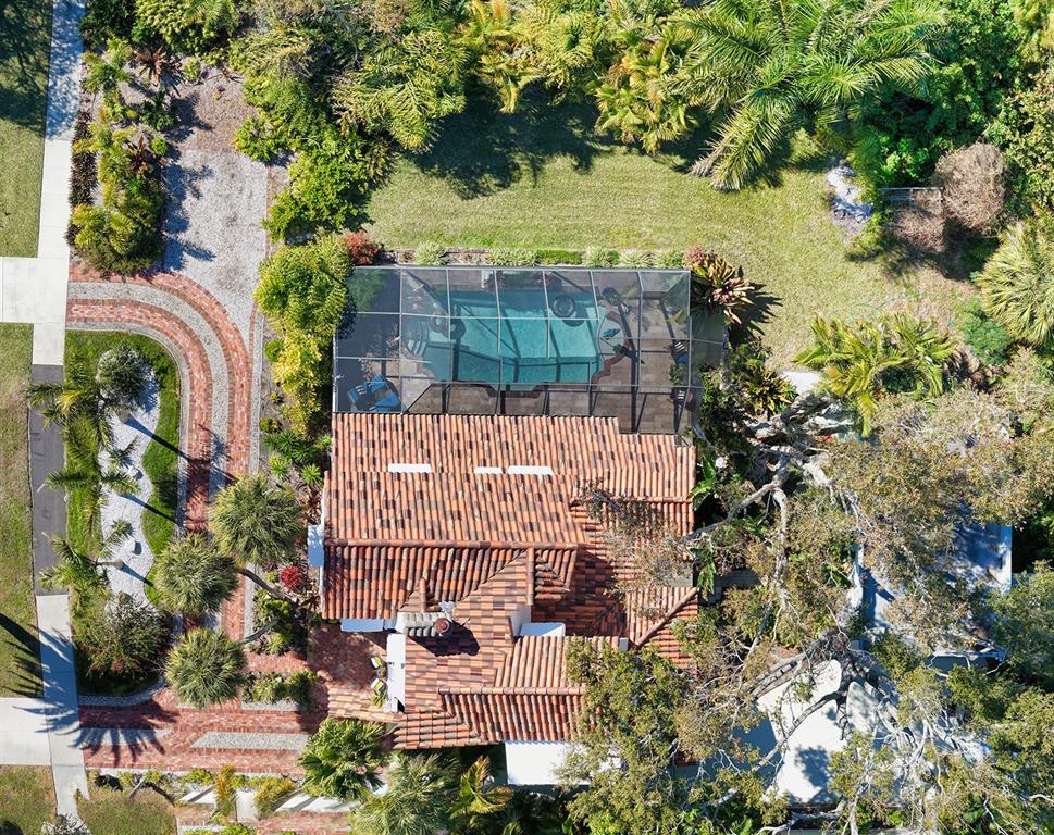 An aerial view shows a house with a tiled roof and a screened-in swimming pool — 547 N SHORE DRIVE, SARASOTA, FL