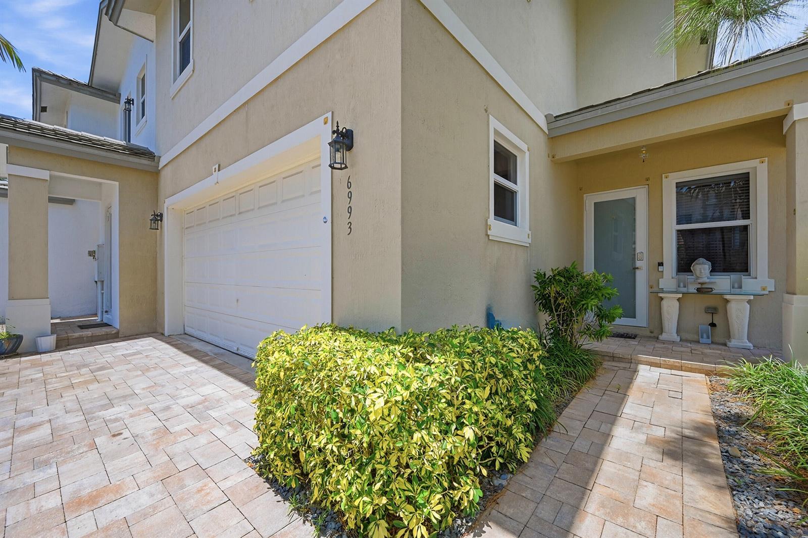 A bedroom features a dark wood canopy bed, a dresser with a television, and a balcony — 6993 Pines Circle, Coconut Creek FL 33073, COCONUT CREEK, FL