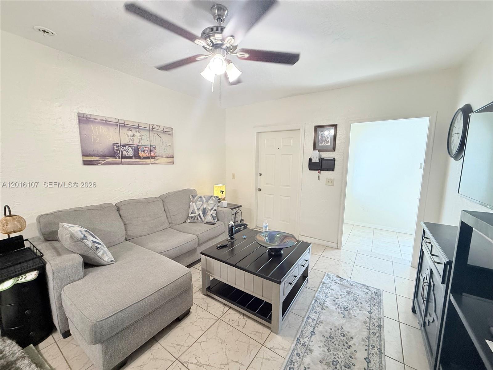 A duplex exterior features two white doors, painted concrete walkways, and a landscaped garden bed — 825 S 20th Ave # A, Hollywood FL 33020, HOLLYWOOD, FL
