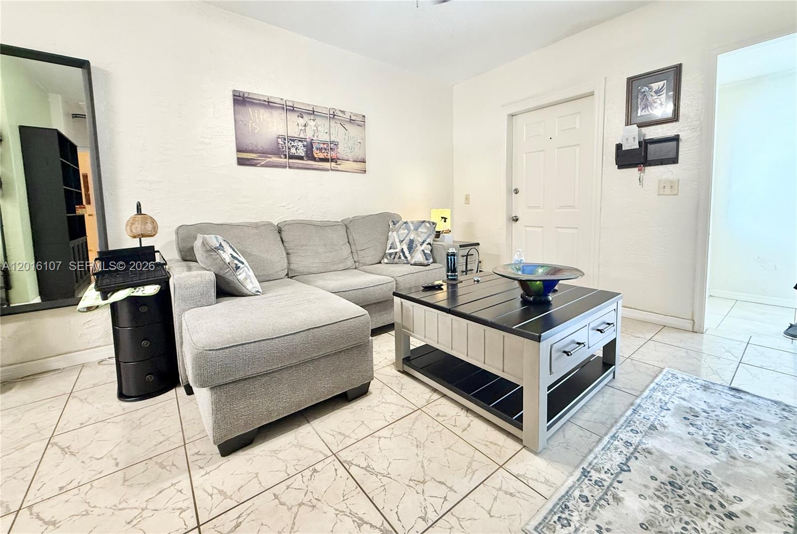 A small outdoor patio features light-colored pavers, a wooden privacy fence, and a gate — 825 S 20th Ave # A, Hollywood FL 33020, HOLLYWOOD, FL