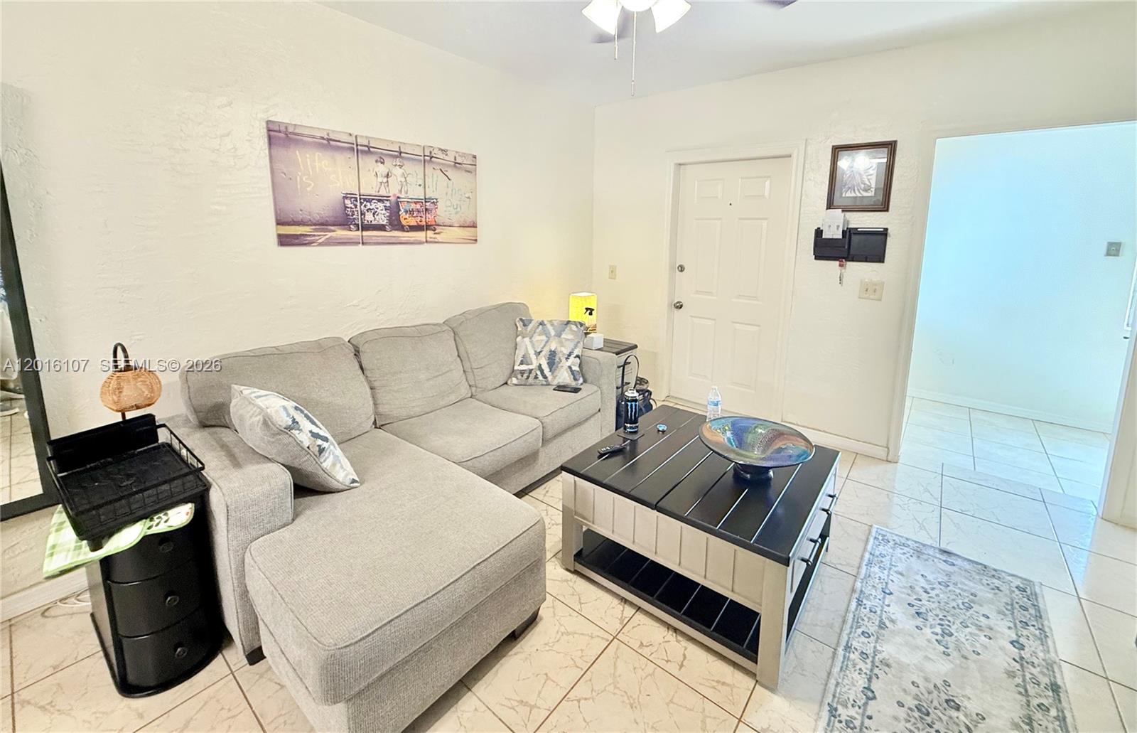 A bathroom with a white vanity and toilet sits next to a louvered closet door — 825 S 20th Ave # A, Hollywood FL 33020, HOLLYWOOD, FL