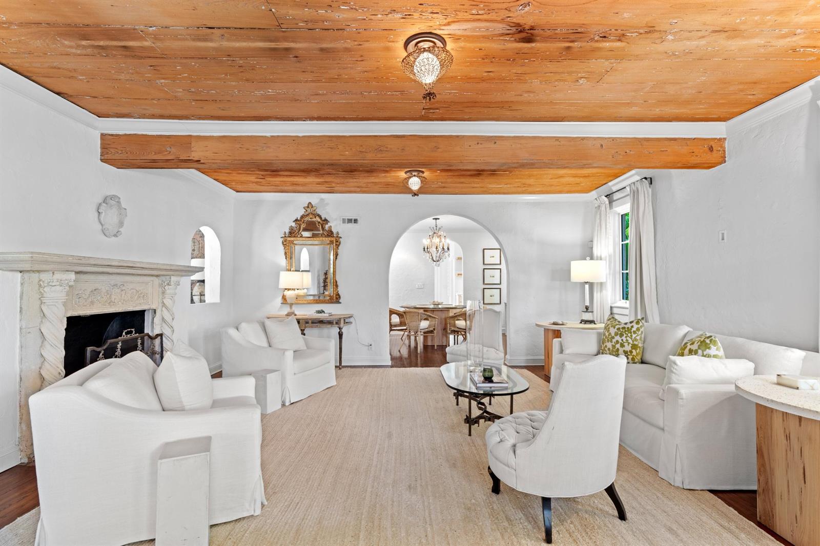 A living room features white furniture, a fireplace, exposed wood ceiling beams, and arched doorways — 746 Upland Road, West Palm Beach FL 33401, WEST PALM BEACH, FL