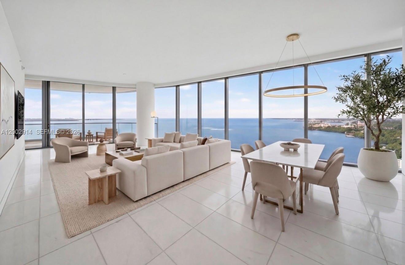 A bright, open-concept living and dining area features floor-to-ceiling windows with expansive ocean views — 175 SE 25 Rd # 2602, Miami FL 33129, MIAMI, FL