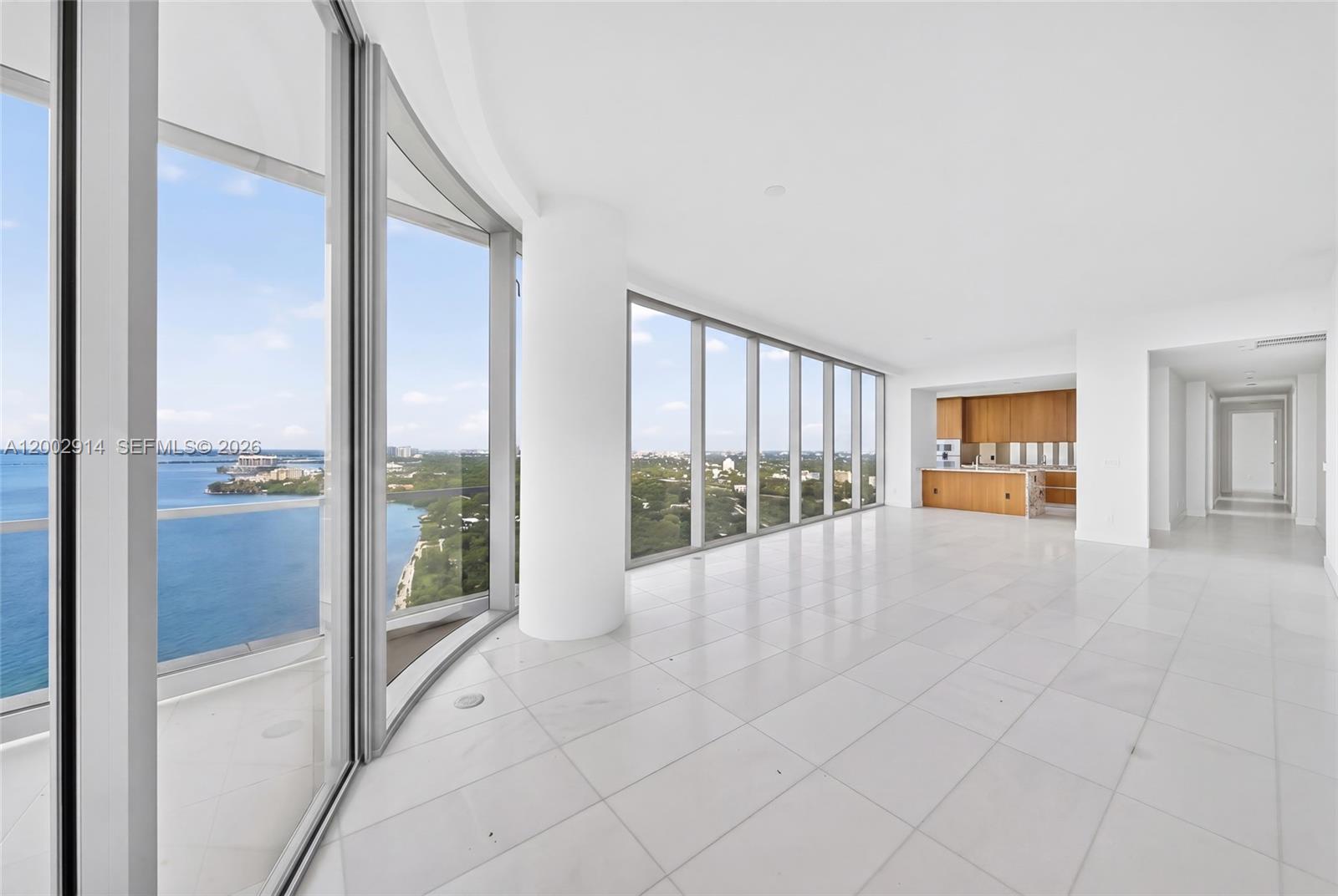 A bright, open-concept living area features white tile flooring, floor-to-ceiling windows, and a kitchen — 175 SE 25 Rd # 2602, Miami FL 33129, MIAMI, FL