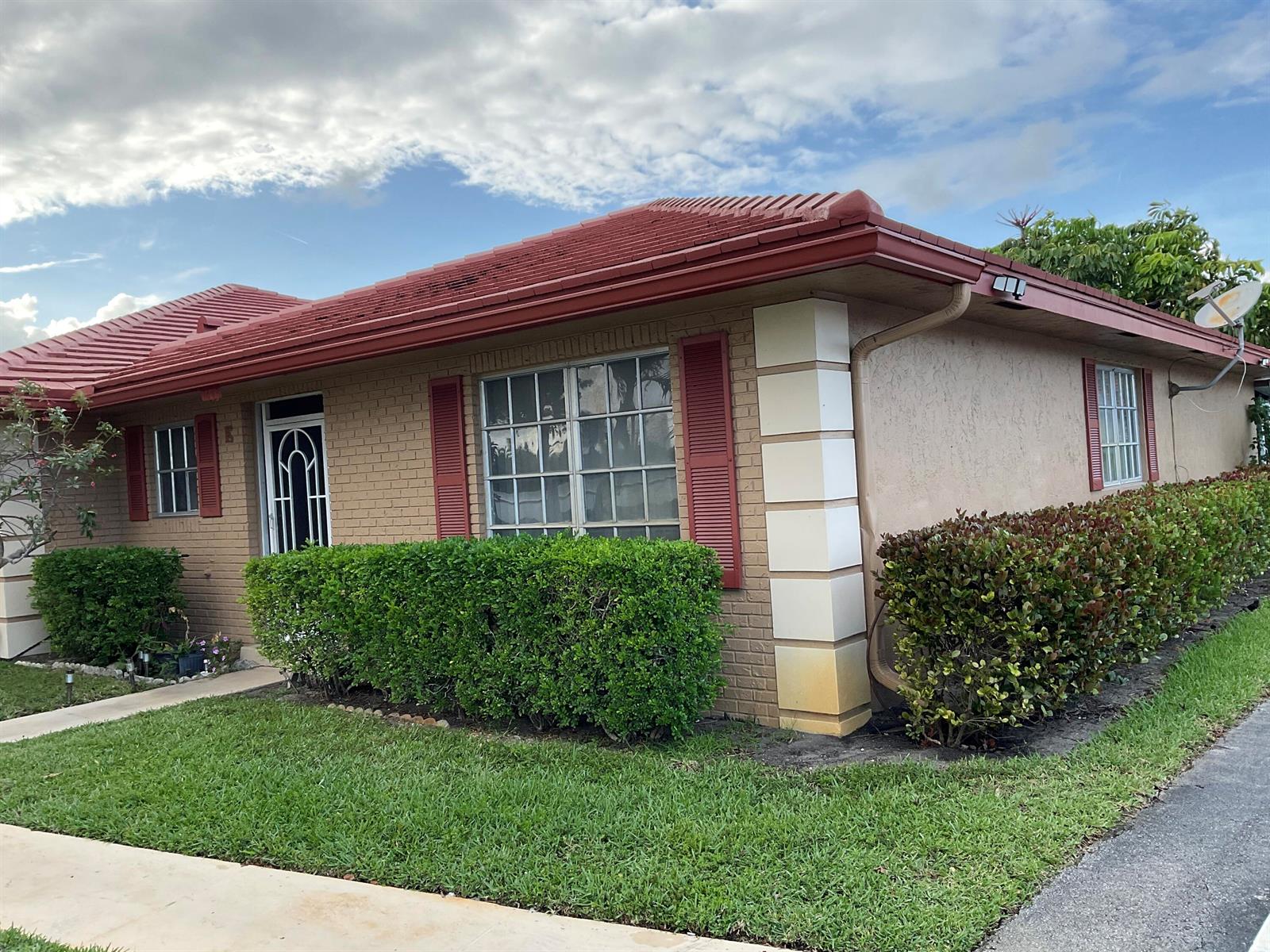 A single-story brick house with a red tile roof, shutters, and a manicured hedge — 1473 SW 27th Avenue # 1e, Boynton Beach FL 33426, BOYNTON BEACH, FL