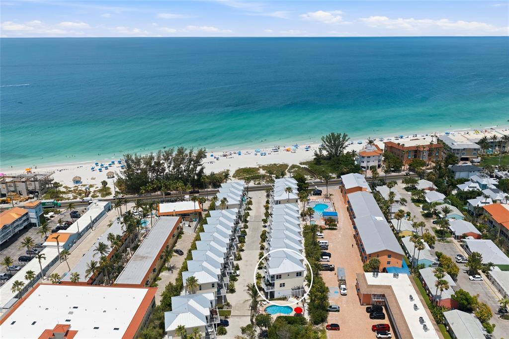 An aerial view shows a row of beach houses with a circled unit and pool — 1473 GULF DRIVE N, BRADENTON BEACH, FL
