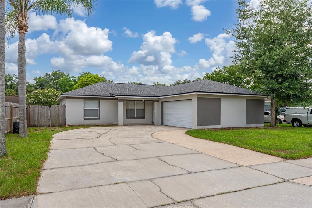A single-story house with a gray exterior, a two-car garage, and a cracked concrete driveway — 631 STANFORD DRIVE, ALTAMONTE SPRINGS, FL