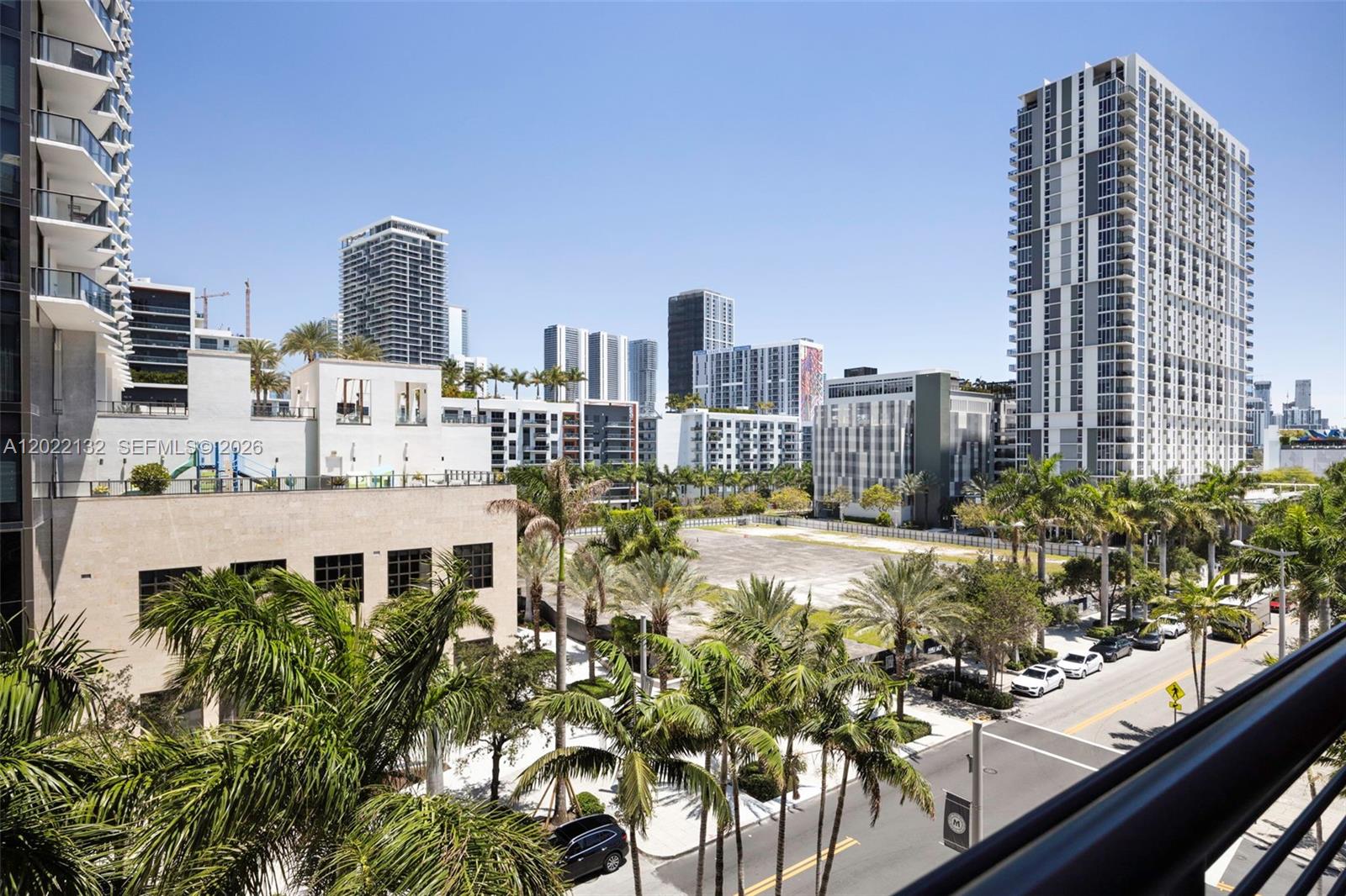 An elevated view shows a vacant lot surrounded by palm trees and modern high-rise buildings — 90 NE 32nd St # 504, Miami FL 33127, MIAMI, FL
