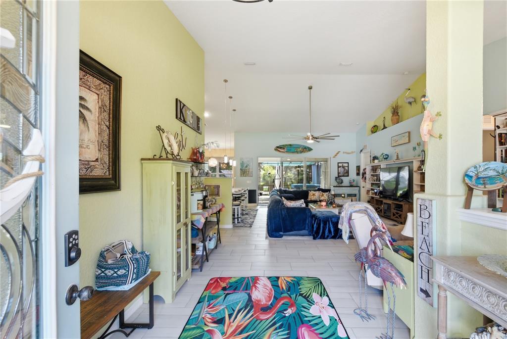 A view from an entryway into a living room with tile floors and tropical decor — 225 BIRCHWOOD DRIVE, PALM COAST, FL