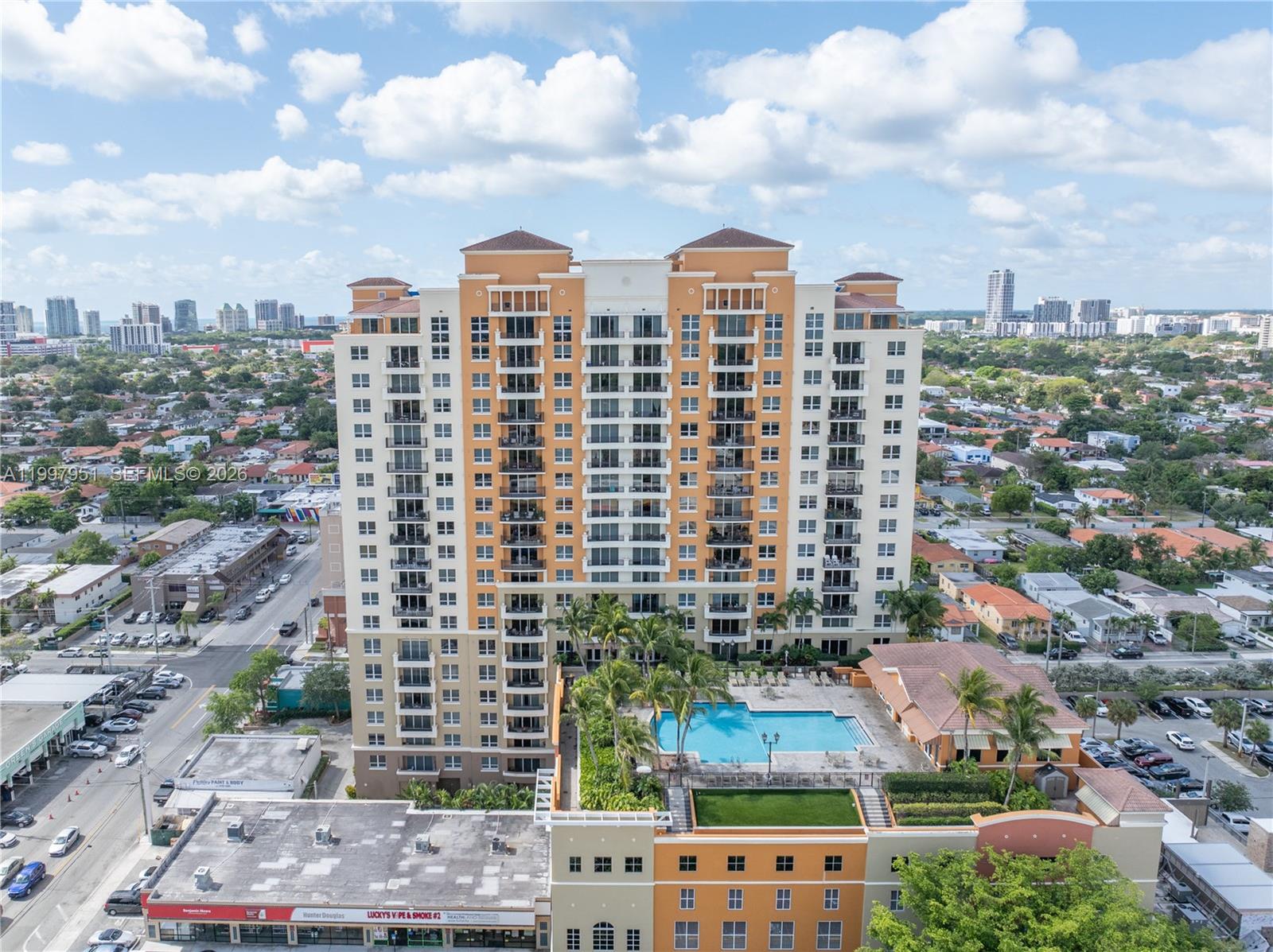 An aerial view shows a tall residential building with a pool deck and surrounding city — 3232 SW 22nd Ter # 607, Miami FL 33145, MIAMI, FL