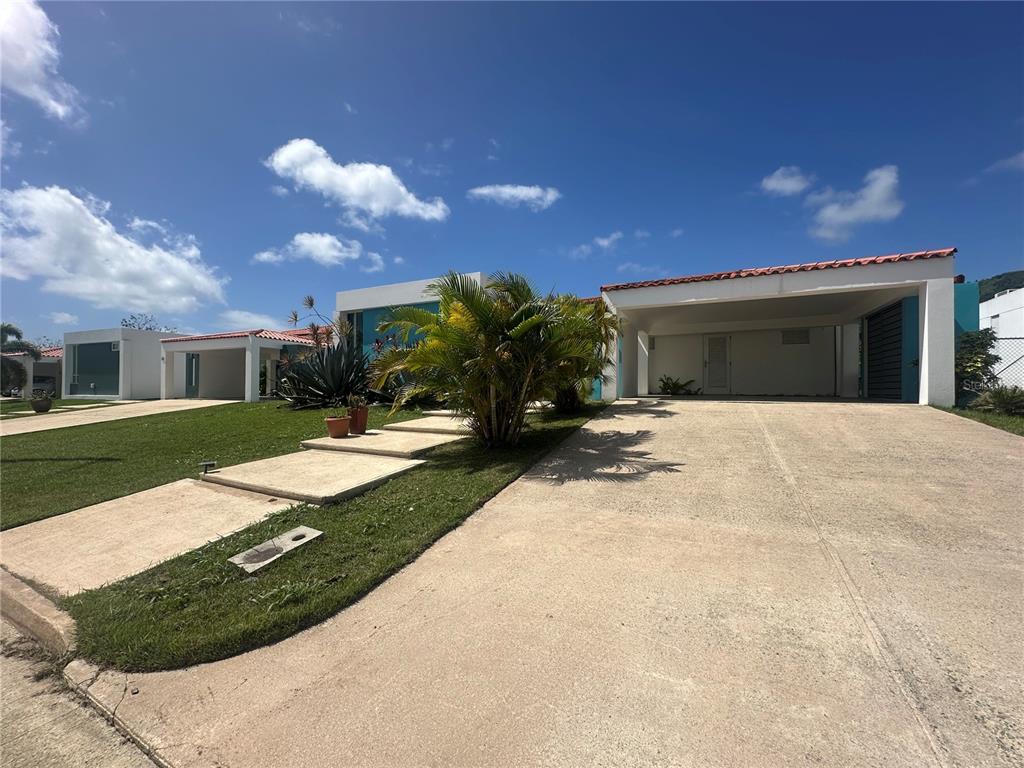 A single-story house with a flat roof, a carport, and a concrete driveway — 67 Los Sueños 67 LOS SUEÑ0S CIUDAD JARDIN, GURABO, PR