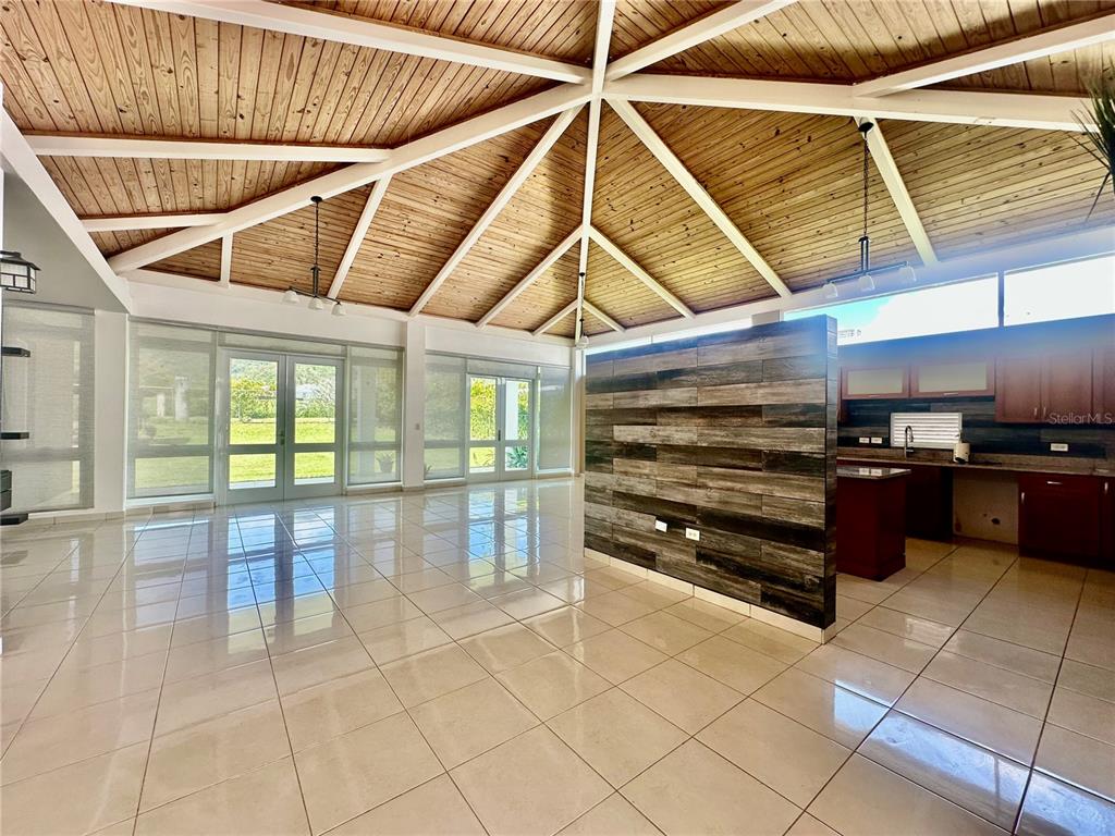A spacious room features a vaulted wood-paneled ceiling, tiled floors, and a wood-accented partition wall — 67 Los Sueños 67 LOS SUEÑ0S CIUDAD JARDIN, GURABO, PR