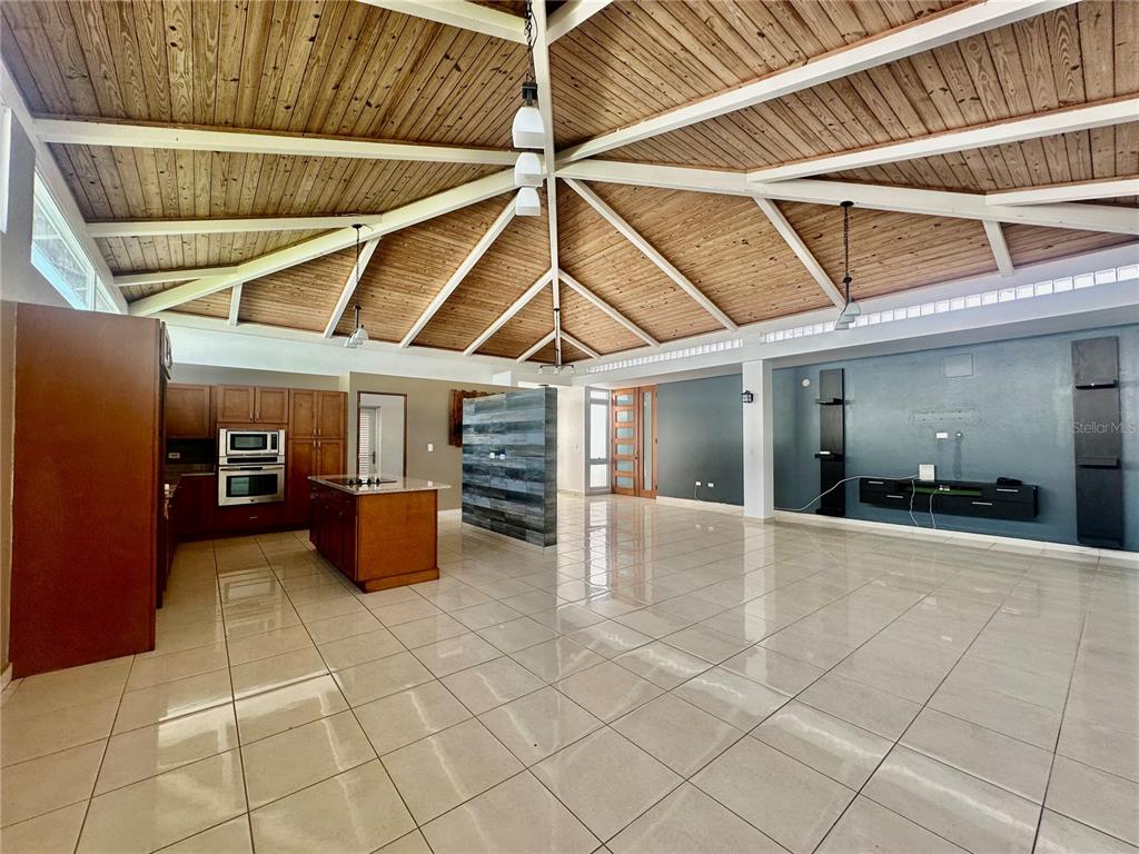 A spacious open-concept living area features a vaulted wood ceiling, tile floors, and a kitchen — 67 Los Sueños 67 LOS SUEÑ0S CIUDAD JARDIN, GURABO, PR