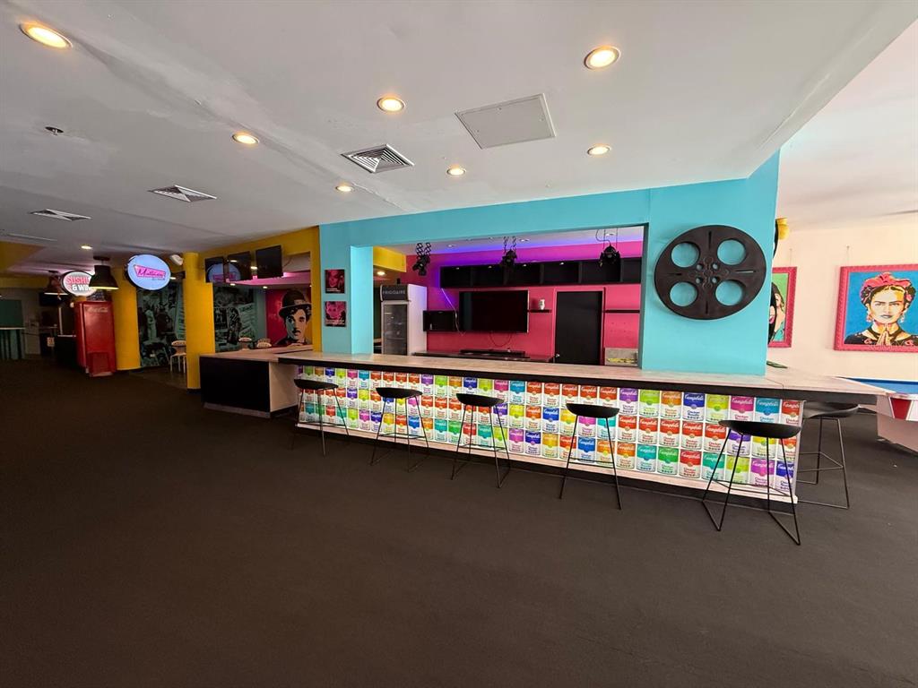 A bar area features a counter decorated with colorful soup can graphics and black stools — 86 CALLE REINA ST, PONCE, PR