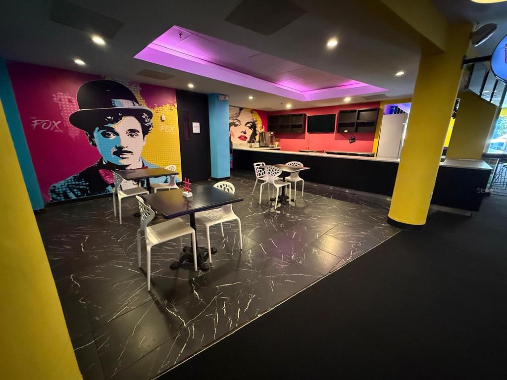 A lounge area features a Charlie Chaplin mural, marble-patterned flooring, and a service counter — 86 CALLE REINA ST, PONCE, PR
