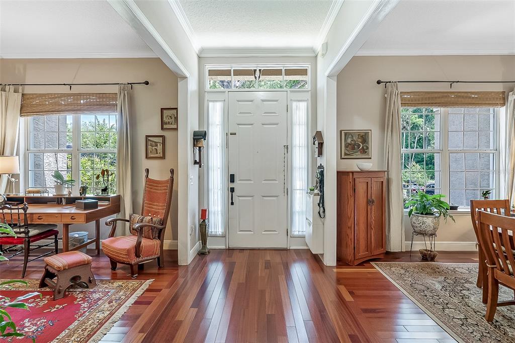 A bright entryway features a white front door, hardwood floors, and windows with bamboo shades — 629 RYAN COURT, WINTER SPRINGS, FL