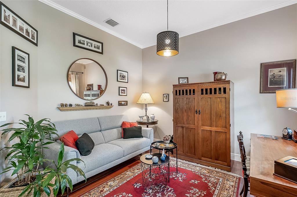 A living room features a gray sofa, a wooden armoire, and a red area rug — 629 RYAN COURT, WINTER SPRINGS, FL