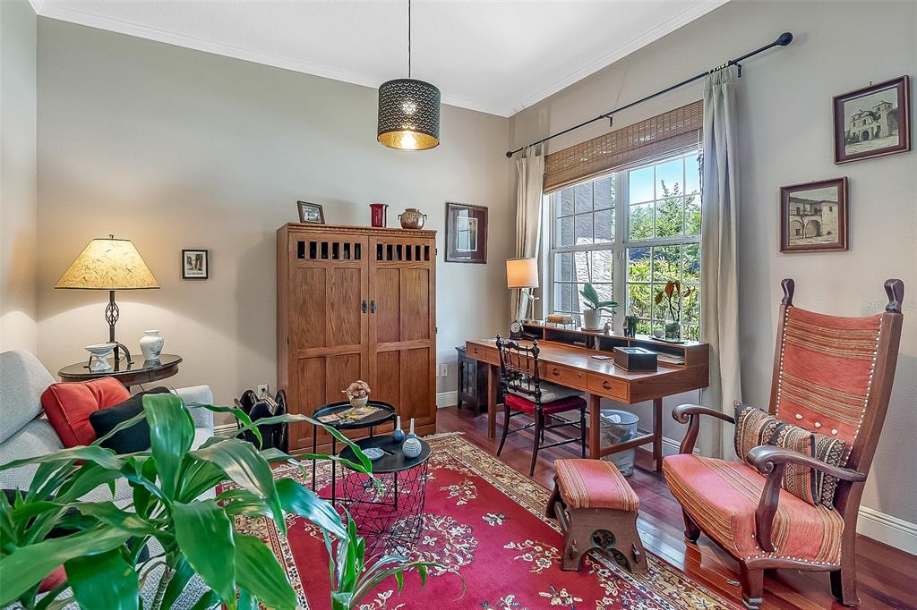 A home office features a wooden desk, a tall cabinet, a red rug, and seating — 629 RYAN COURT, WINTER SPRINGS, FL