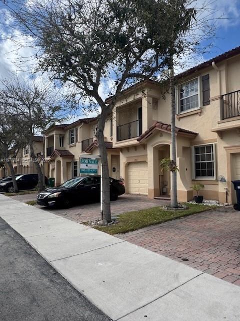 A row of beige townhouses with a black car parked in front on a sunny day — 12923 SW 135th Ter, Miami FL 33186, MIAMI, FL